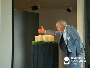Prof. Jochen Abke pustet beim feierlichen Teil des Festaktes Kerzen aus. Foto: TH Lübeck 