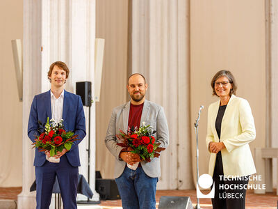 Doktoranten mit Blumensträußen stehen neben TH Lübeck Präsidentin