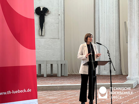 TH Lübeck Präsidentin steht am Rednerpult der Sankt Petri Kirche