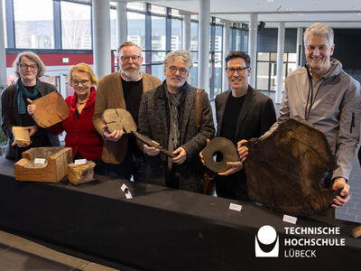 Personen halten unterschiedlich große Holzstücke in der Hand