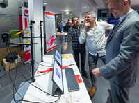 Teilnehmer der Night of AI 2024 interagieren mit einem KI-Demonstrator an einem Stand der Technischen Hochschule Lübeck.