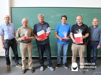 Der krönende Abschluss der letzten Konventssitzung: Dr. Tillmann Schmelter und Dekan Stephan Klein (links und rechts außen) zeichnen die Professoren Ullrich Wenkebach, Peter Swidersky, Stefan Müller und Markus Riotte aus. 