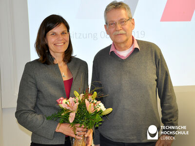 Der stellvertretende Senatsvorsitzende und ehemalige Präsident der TH Lübeck, Prof. Dr. Stefan Bartels-von Mensenkampff, gratuliert der amtierenden und bis 2026 bestätigten Präsidentin, Dr. Muriel Kim Helbig. Foto: TH Lübeck