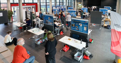 Hier sieht man viele Stände mit den Aufbauten der Schüler*innen von Jugend Forscht