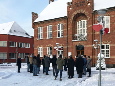 Menschen mit Schnee vor einem Gebäude