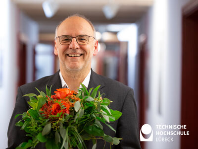 Lächelnder Mann hält Blumenstrauß in den Händen