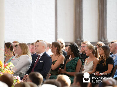 Studierende sitzen in Reihen in einer Kirche 