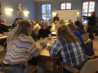 Studierende sitzen an einem Tisch und unterhalten sich