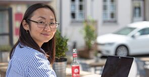 Studentin sitzt draußen vor einem Laptop