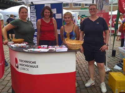 Foto zeigt vier Personen an dem TH Lübeck Stand