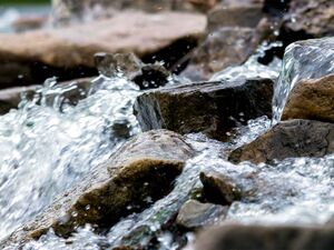 Hier sieht man Wasser über Steine fließen 