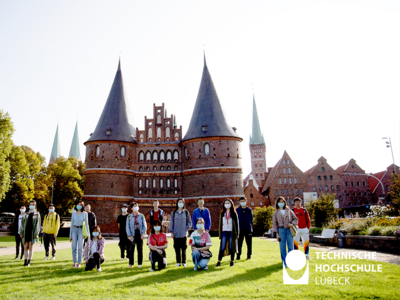 An einem sonnigen Herbsttag posieren einige Studierende des 14. ECUST Jahrgangs vor dem Holstentor.