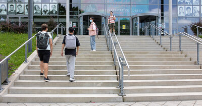 Vier Studierende die Treppen zum Audimax hochgehen