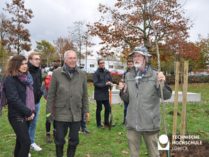 Heinz Egleder (rechts) erläutert den Anwesenden den Pflanzbeschnitt, Stifter Dr. Stefan Schreiber (Mitte) verfolgt aufmerksam, was es zu beachten gilt. Foto: TH Lübeck